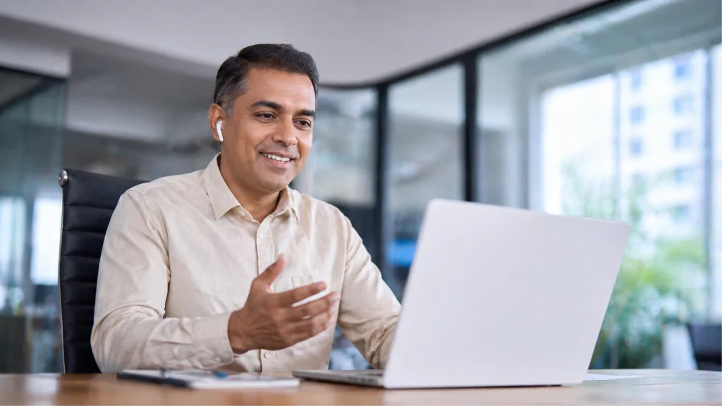 Geschäftsmann lernt mit einem LMS für Kundenschulungen am Laptop in einer Videosession.