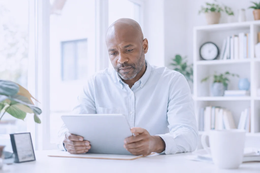 Mitarbeiter prüft am Tablet eine verdächtige E-Mail – Phishing-Schulung im Arbeitsumfeld